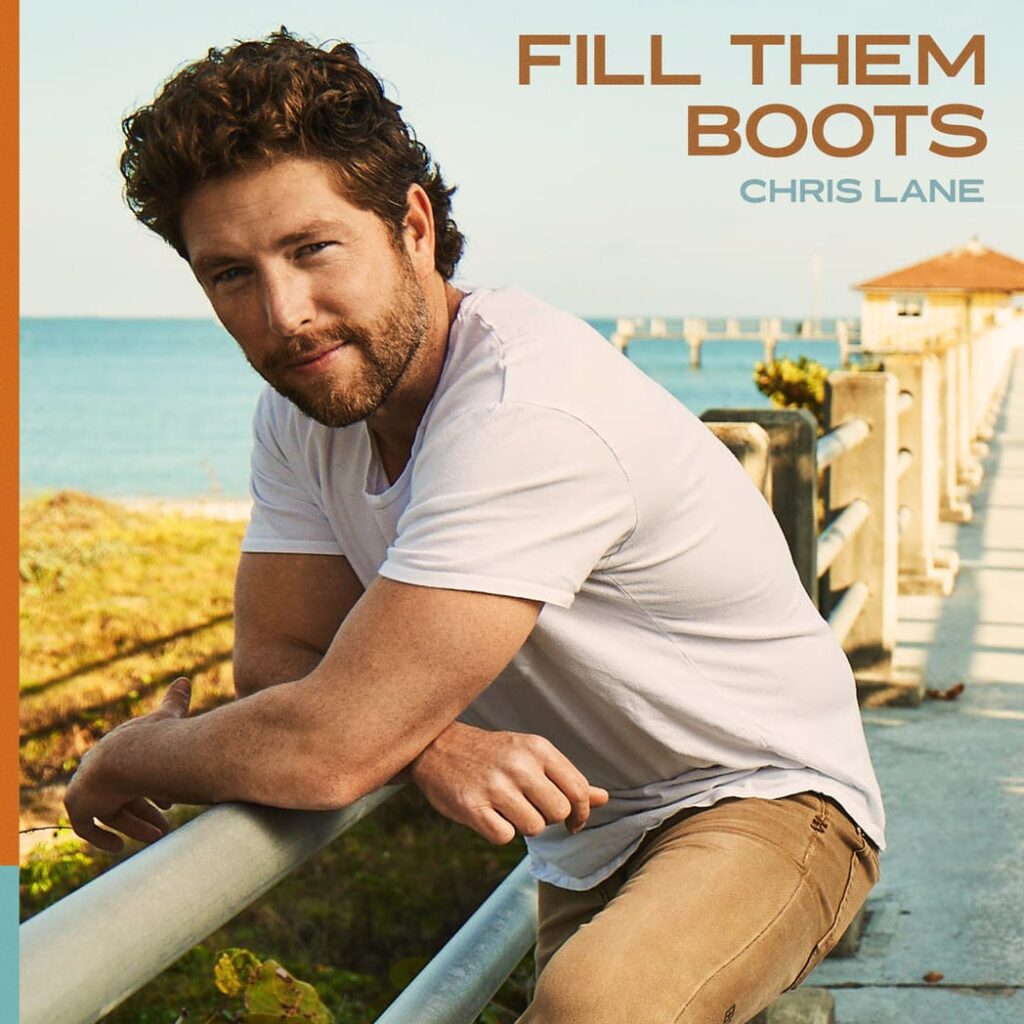 Chris Lane album cover, he is leaning against the railing near the beach with the ocean in the back