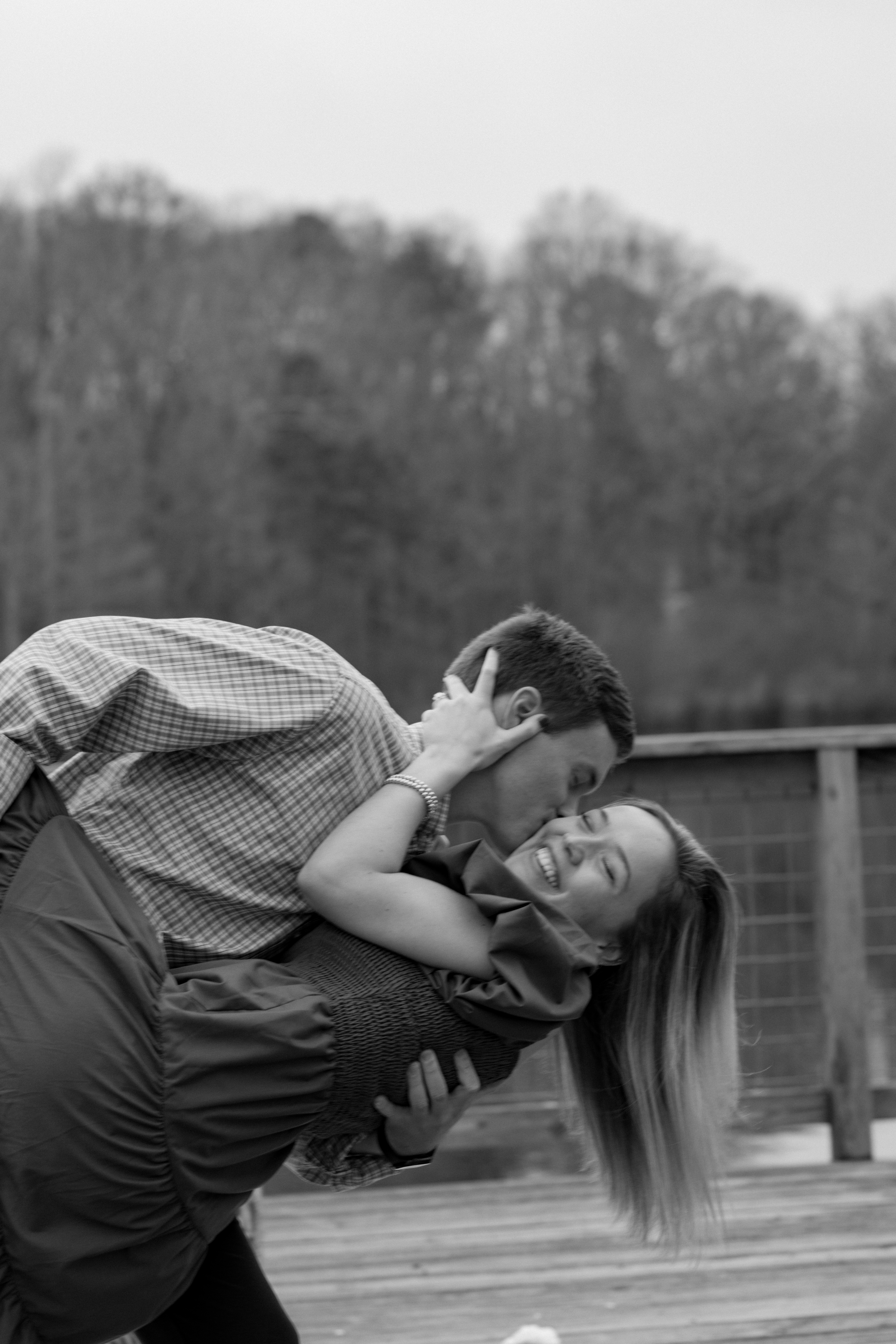 Man dipping woman an kissing her on the cheek, in black and white