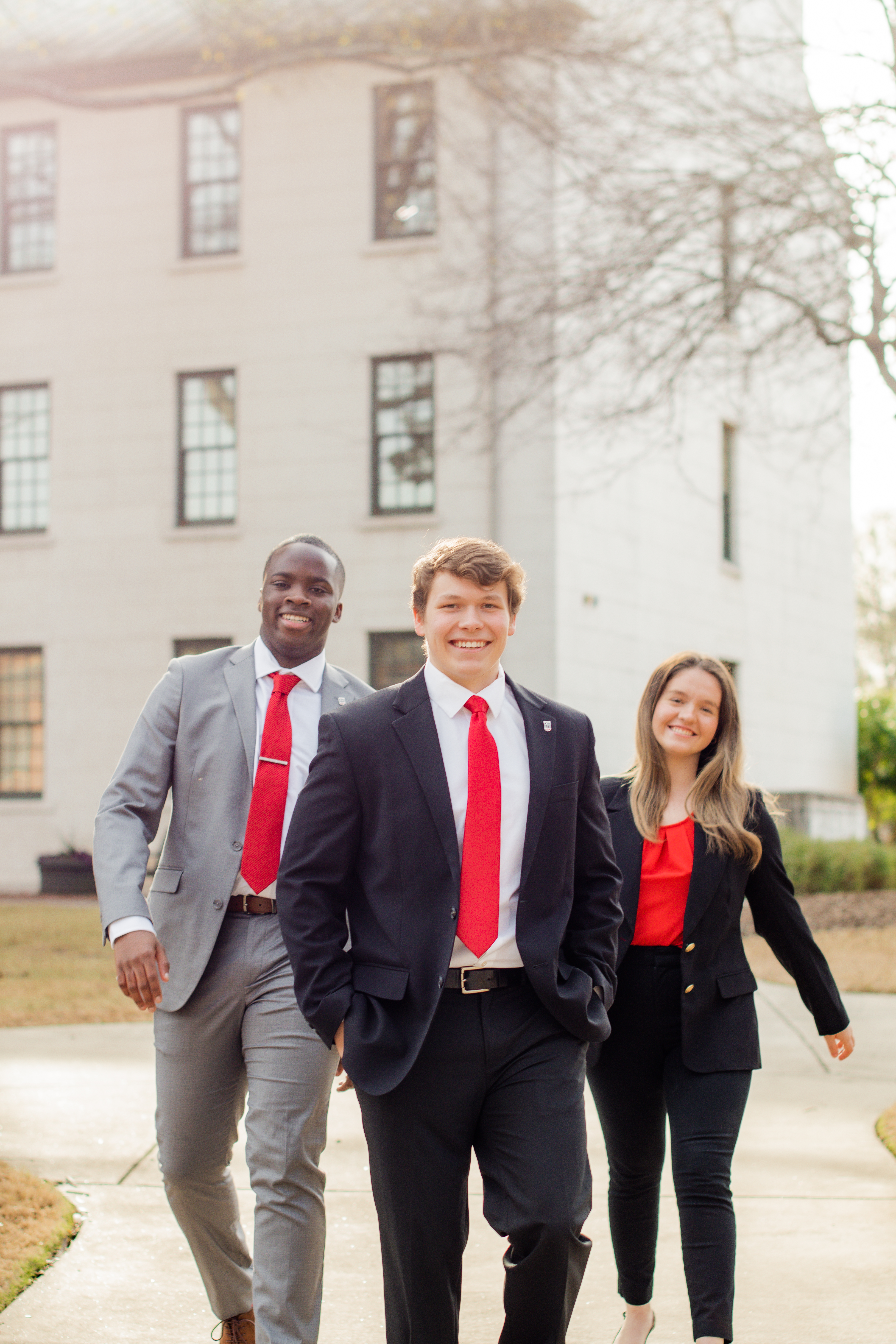 Three college students walking on UGA north campus with sunny background