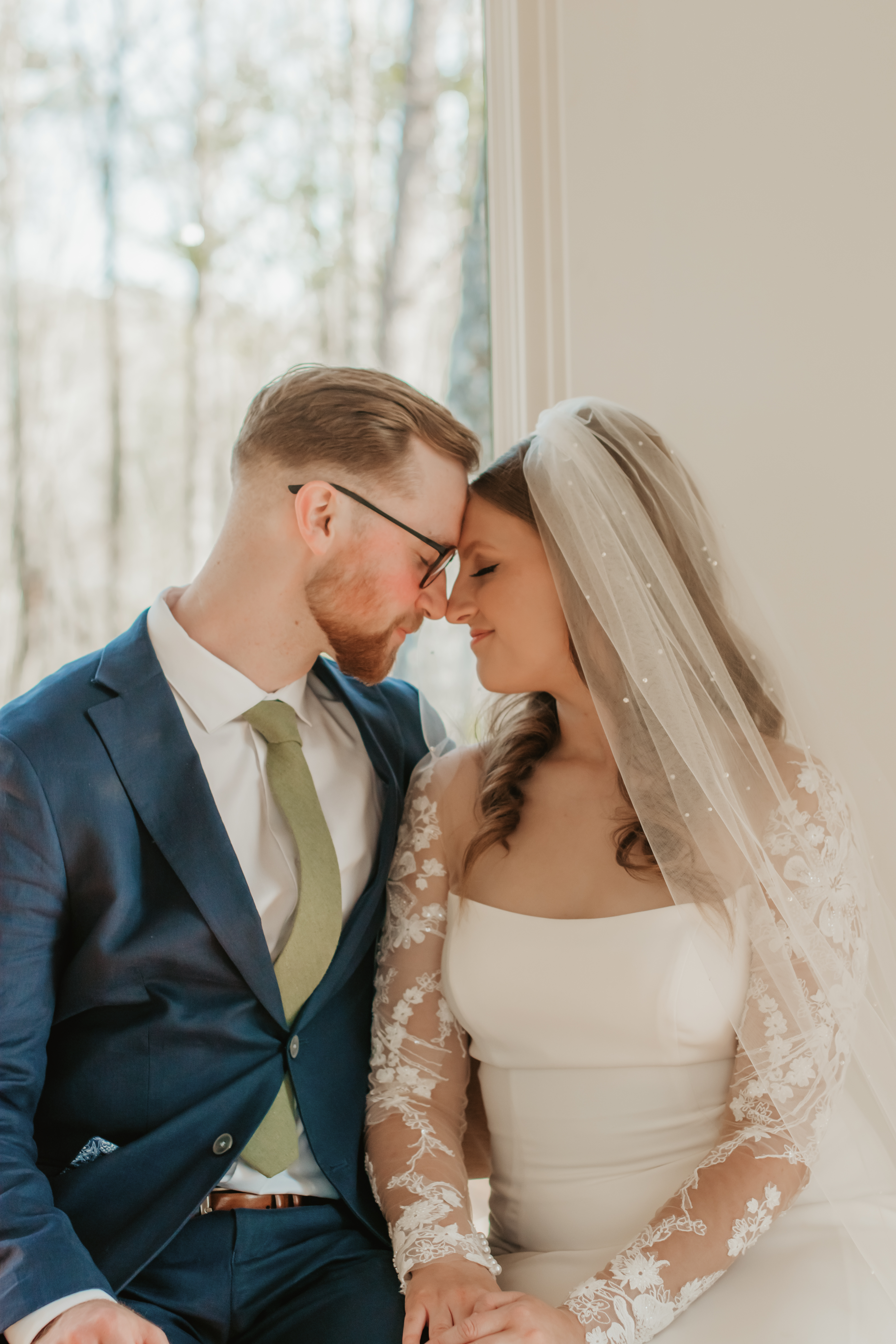 a bride and groom placing their heads together and closing their eyes